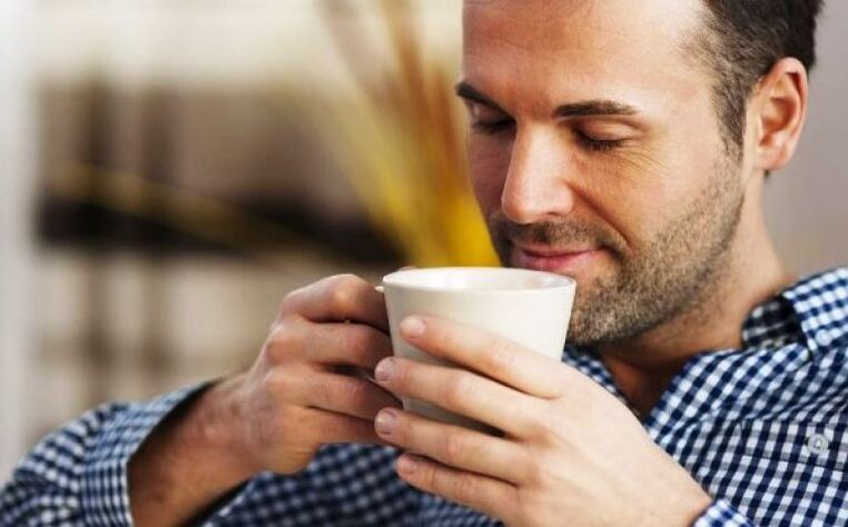 Un home bebe unha bebida de té fireweed para aumentar a potencia